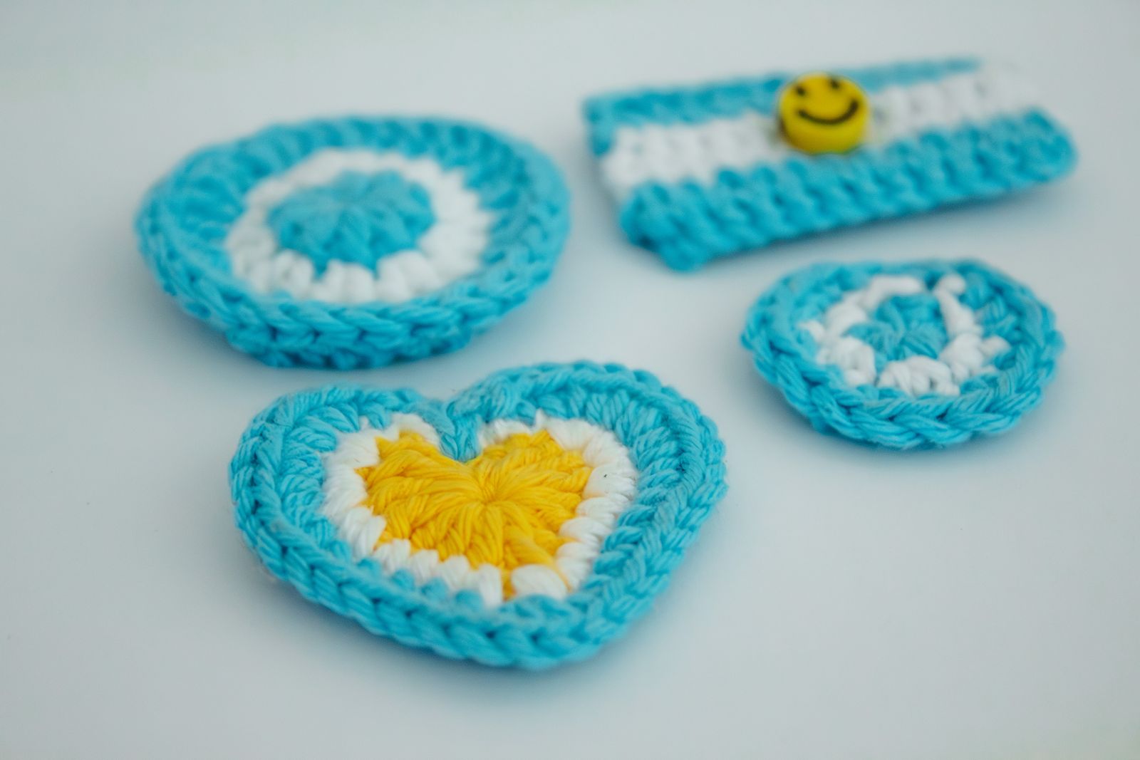 Colorful crocheted coasters with heart accent on a wood surface