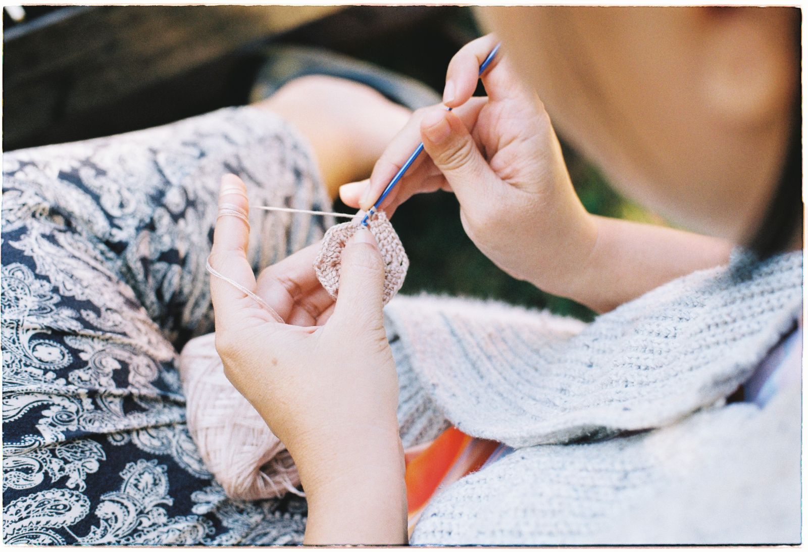 Close-up of a woman finishing crochet work outdoors