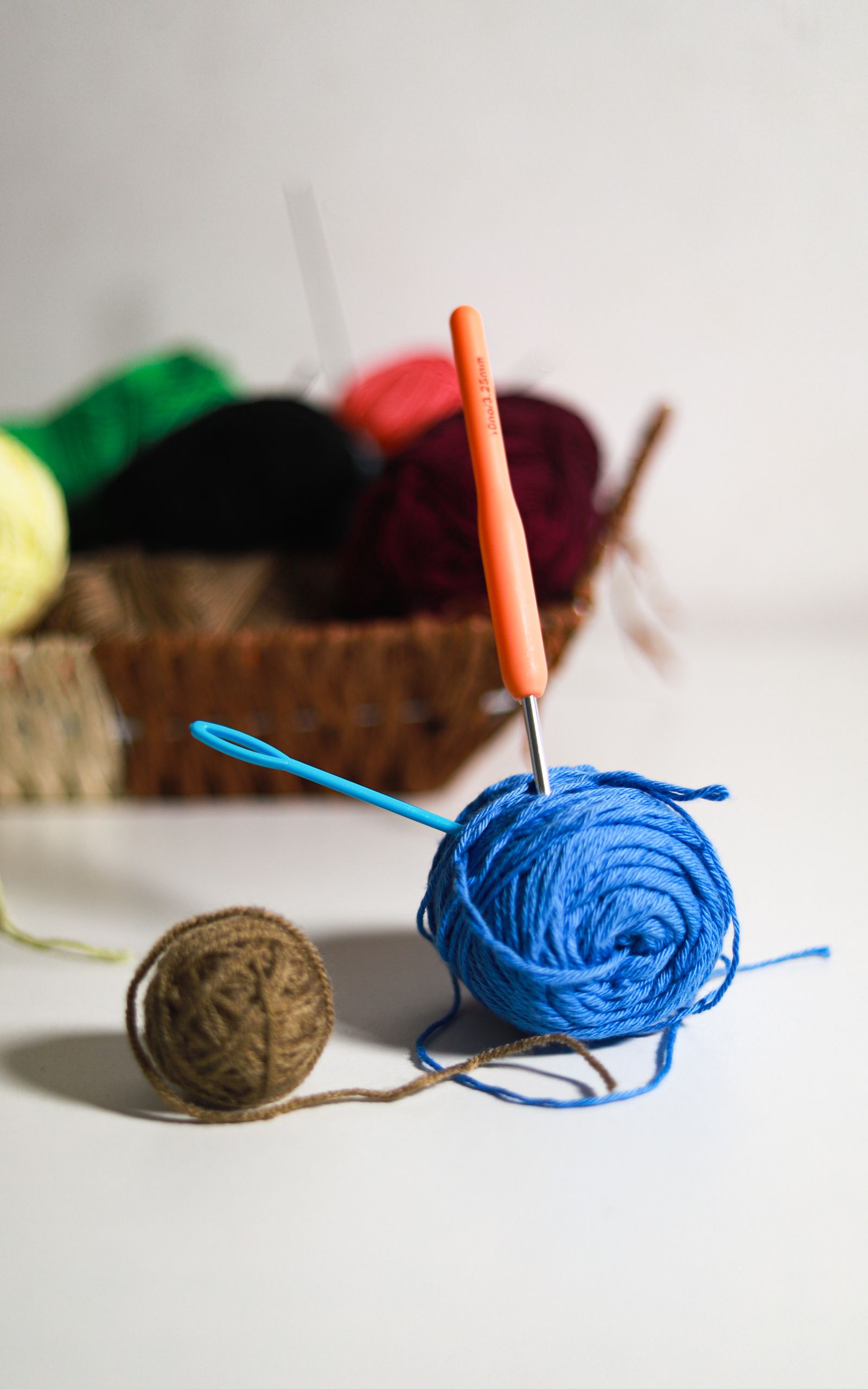 Colorful yarn balls and crochet hooks arranged on a table